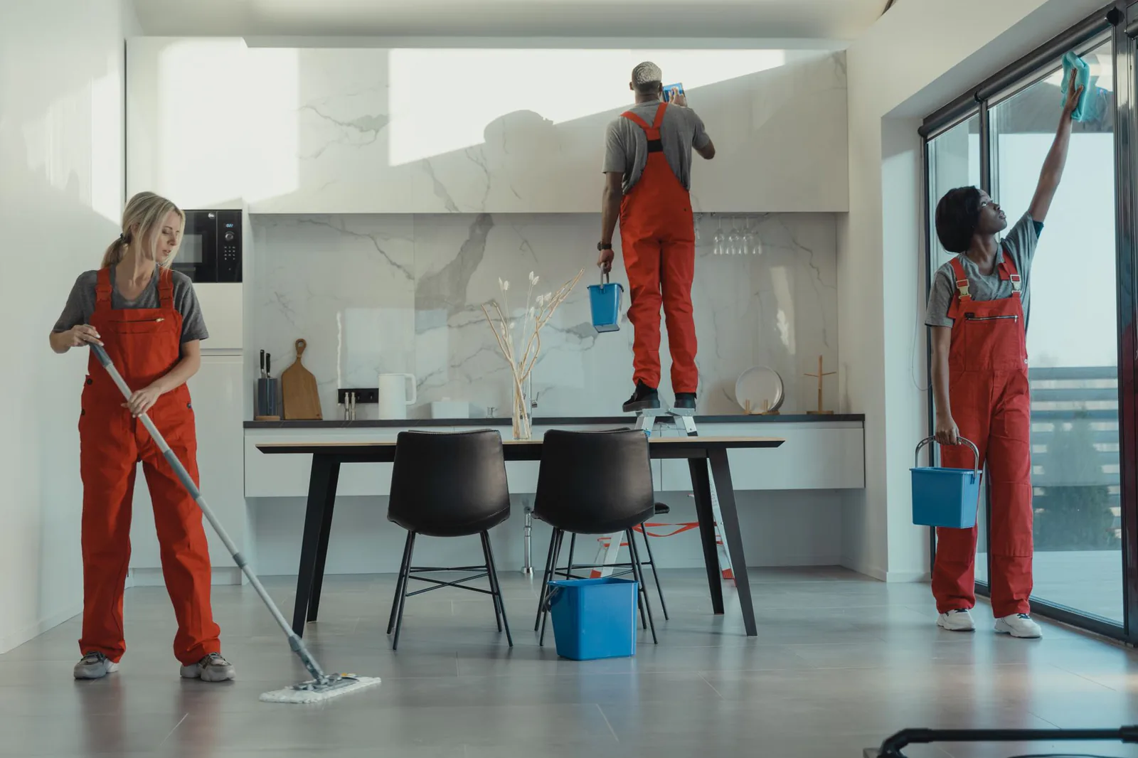 Professional cleaners in uniforms mopping and sanitizing a modern interior, representing the post-AI cleaning business boom