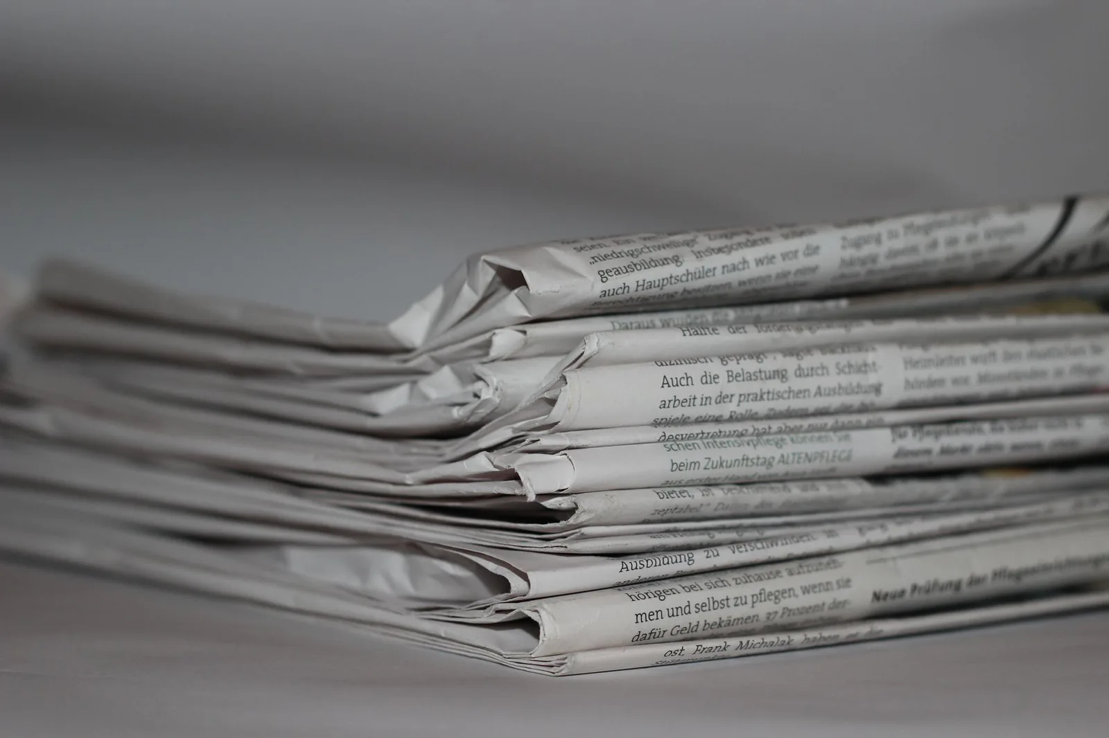 Stacked newspapers representing investigative document archives